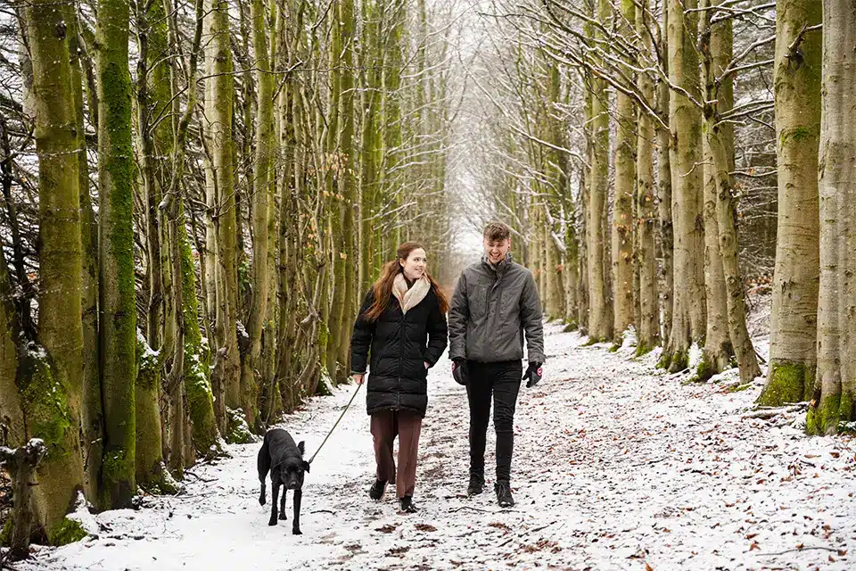 Couple walking through woodland area near Ruthin at Christmas