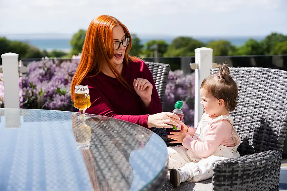 Mum and child enjoying a drink in Conwy