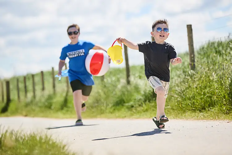 2 children playing on the beach path at Rhyl beach with access to caravan holidays at Lyons Robin Hood